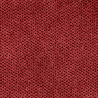 Reddish-brown velvet fabric texture features a dense, repeating circular pattern with a subtly nubby surface and uniform coloration.